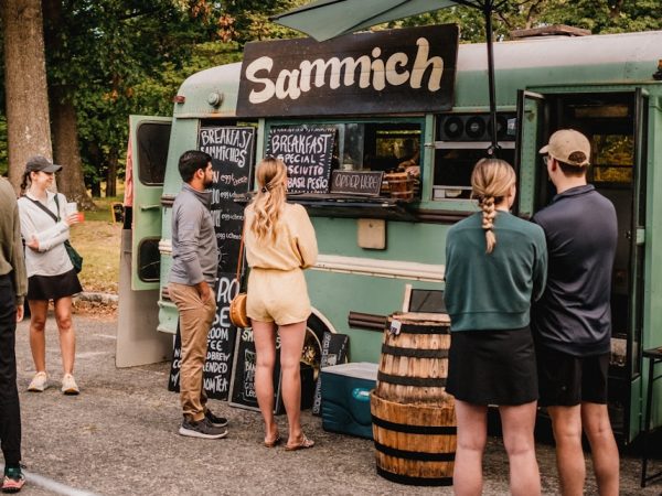 a group of people standing outside of a food truck